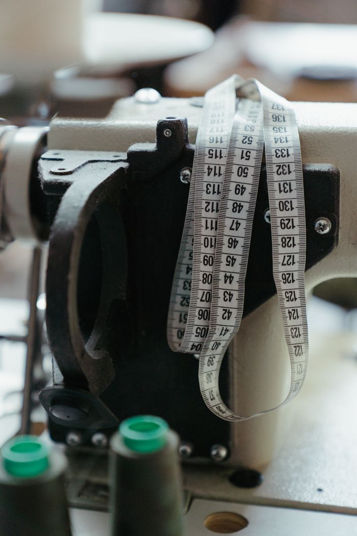 Crafting Captivating Headlines: Your awesome post title goes here Close-up of a sewing machine with measuring tape in a workshop, highlighting tailoring tools.