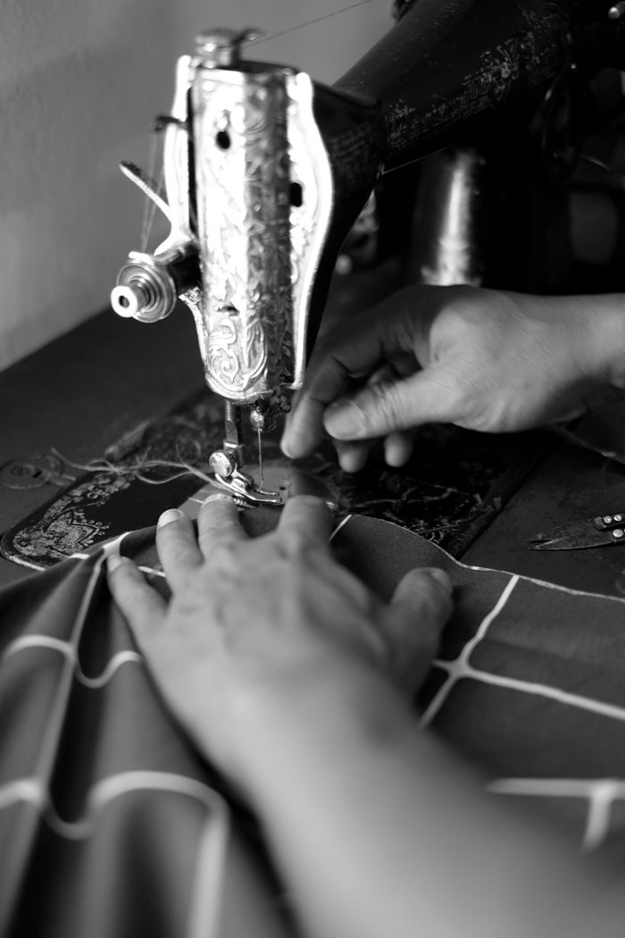 Mastering the First Impression: Your intriguing post title goes here Black and white image of hands operating a vintage sewing machine, creating intricate fabric patterns.