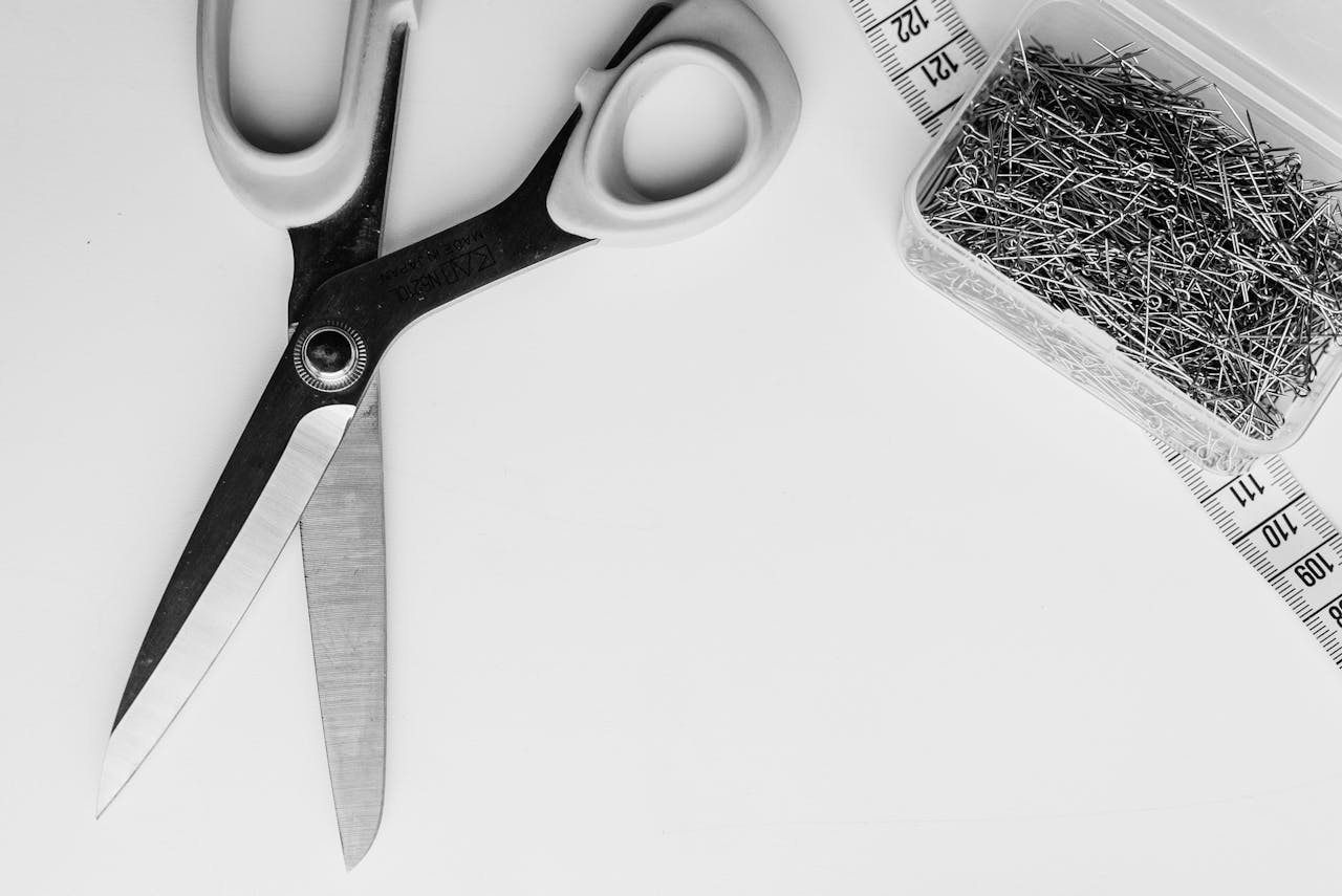 The Art of Drawing Readers In: Your attractive post title goes here Monochrome image of scissors, measuring tape, and pins on white background.
